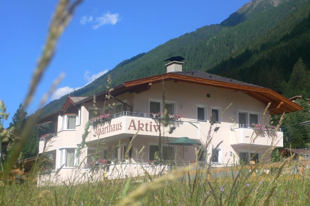 a large white building with a mountain in the background at Aparthaus Aktiv in Neustift im Stubaital