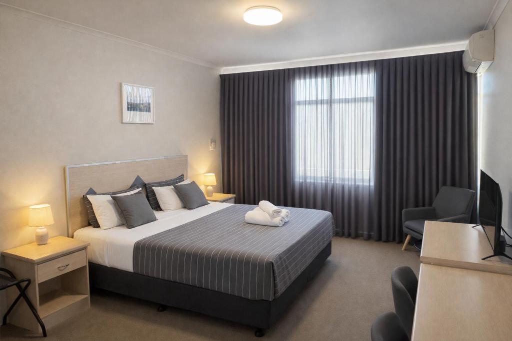 a bedroom with a bed and a television in a room at Highway One Motel in Ceduna