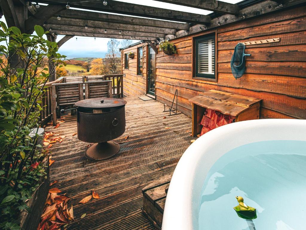 a deck with a hot tub and a picnic table at The Game Keeper - Uk50611 in Sabden