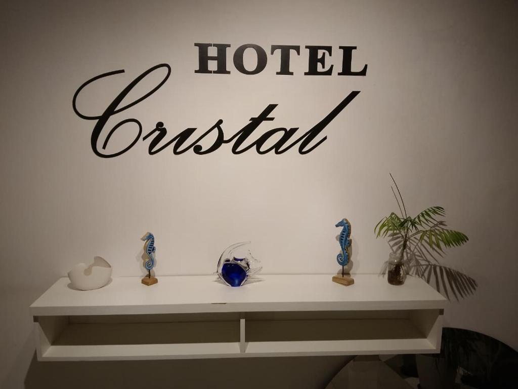 a shelf with vases and a hotel sign on a wall at Hotel Cristal in Viedma