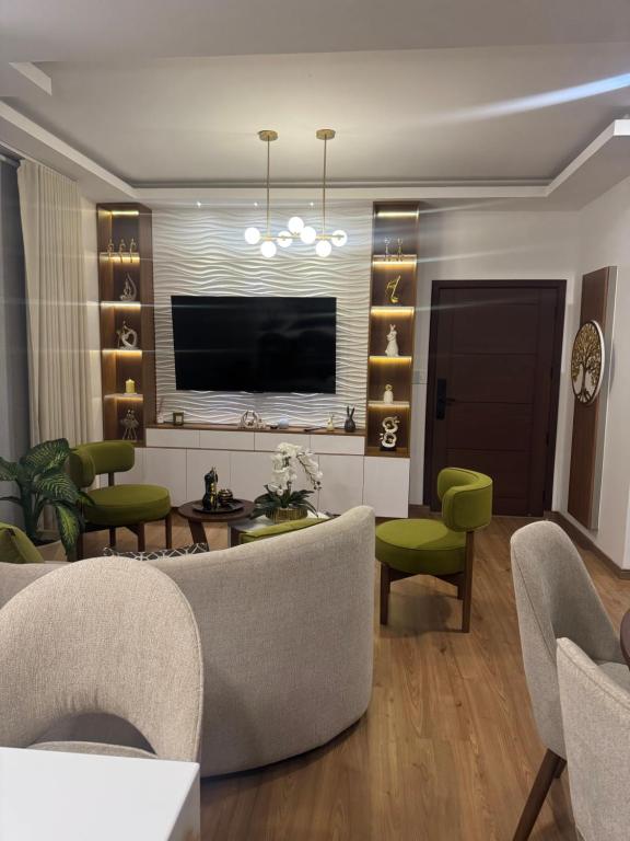 a living room with a couch and chairs and a television at Departamento de lujo inteligente in Cochabamba