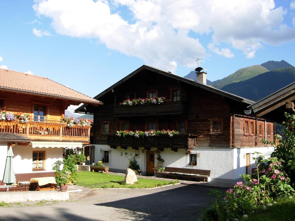 a wooden house with flowers on the balconies of it at Stoanahof in Virgen