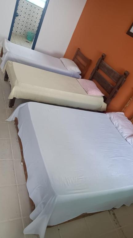 a group of three beds in a room at Pousada hotel da ilha lounge Beach Lucas do Gelo in Ilha Comprida