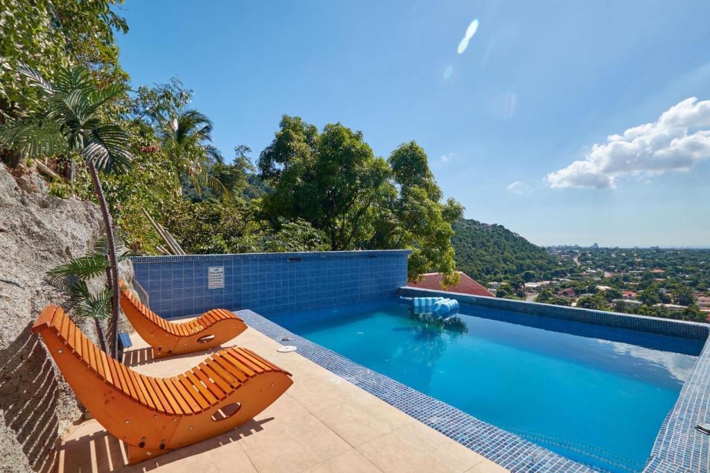 a swimming pool with two lounge chairs on top of a house at Sunset Havendale in Kingston