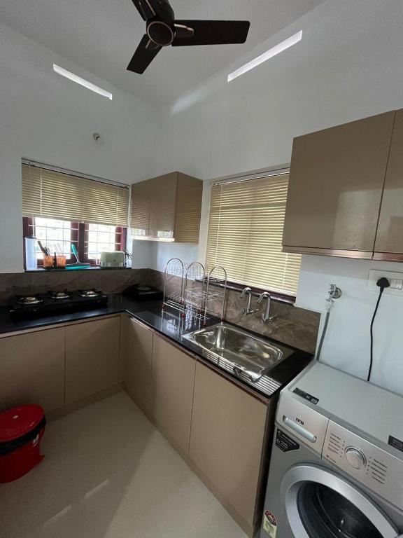a kitchen with a washer and a sink and a stove at MR Homes in Cochin