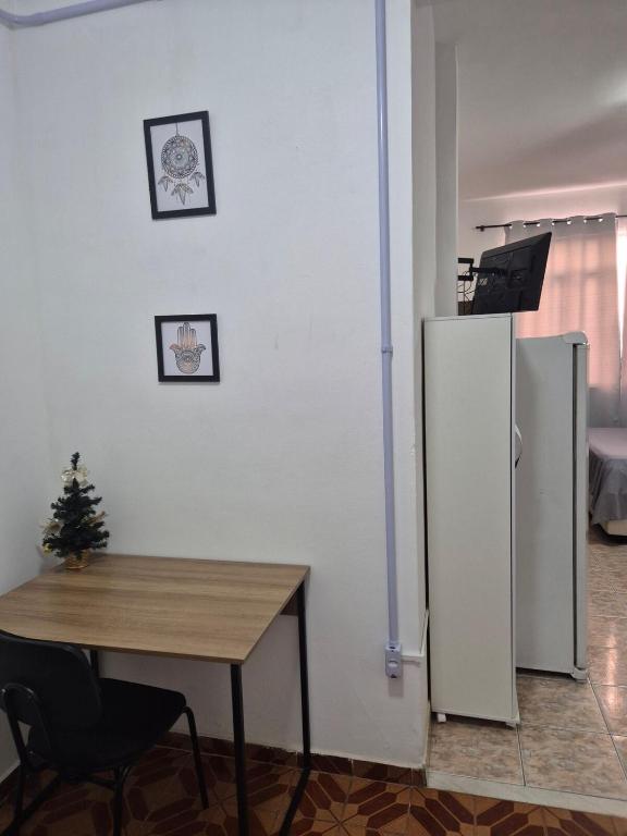a room with a table and a refrigerator at Studio em Piedade in Rio de Janeiro