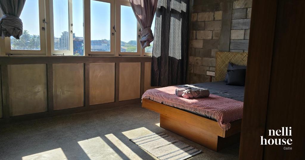 a bedroom with a bed and a window at nelli house in Galle