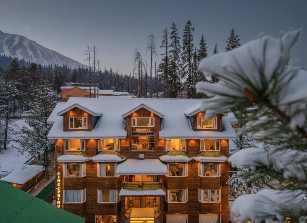 a large building with snow on the roof at Hotel Pine Spring Gulmarg in Gulmarg
