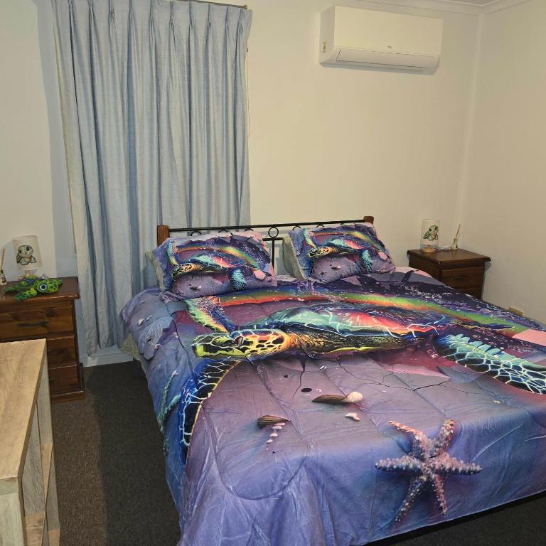 a bedroom with a bed with a purple comforter at Dream Catcher Air B&B in Berri