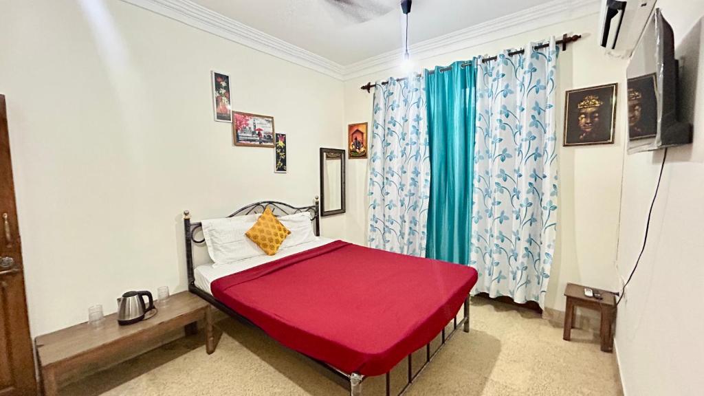 a bedroom with a red bed and a window at Muffys Baga Apartment in Baga