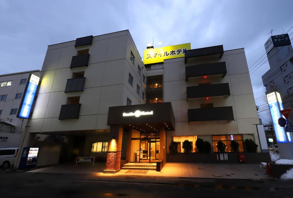 a building with a sign on top of it at Smile Hotel Aomori in Aomori
