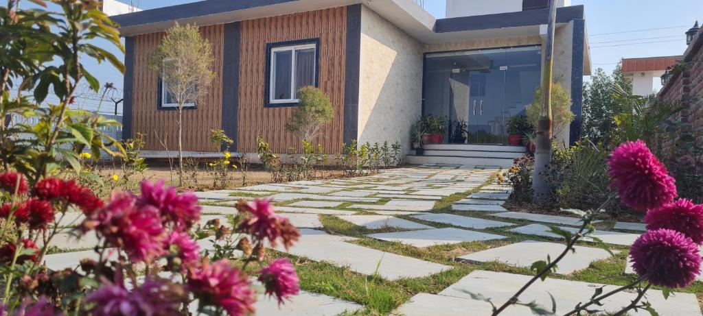 a house with a garden with flowers in front of it at AmarVandana Palace in Rādha Kund