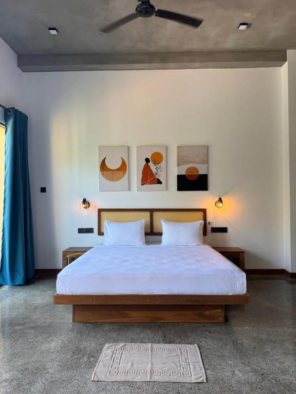 a bedroom with a large bed with two pillows at Cielo Hiriketiya in Hiriketiya