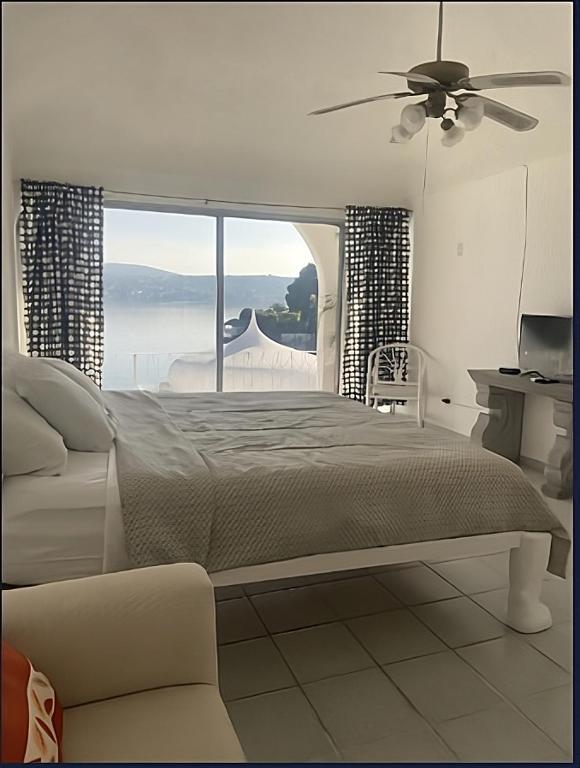 a bedroom with a bed and a large window at Hotel Marina Palace Tequesquitengo in Tequesquitengo