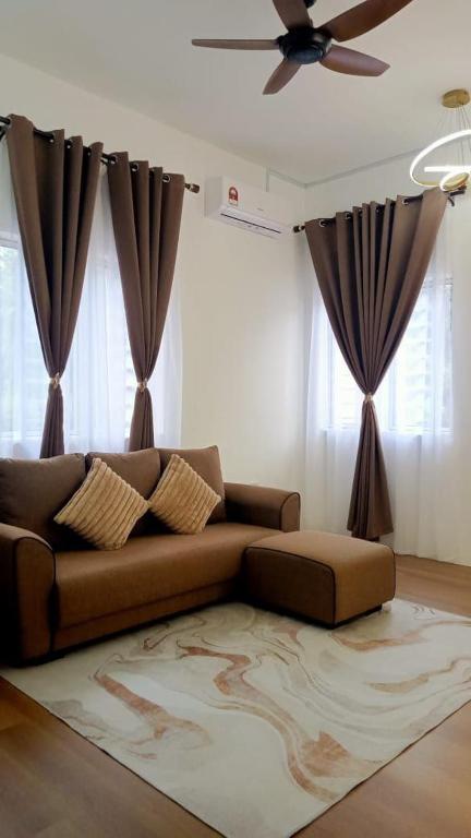 a living room with a brown couch and curtains at Risfeena Home in Sekinchan