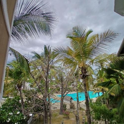 a view of a resort with palm trees and a pool at Tatia apartment in Malindi