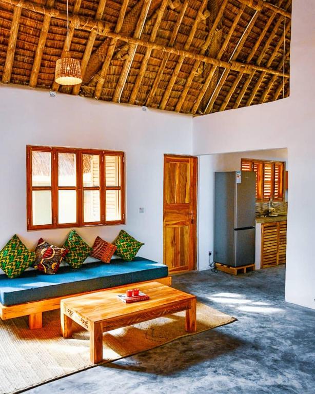 a living room with a blue couch and a table at Amani Beach House, Ushongo in Pangani