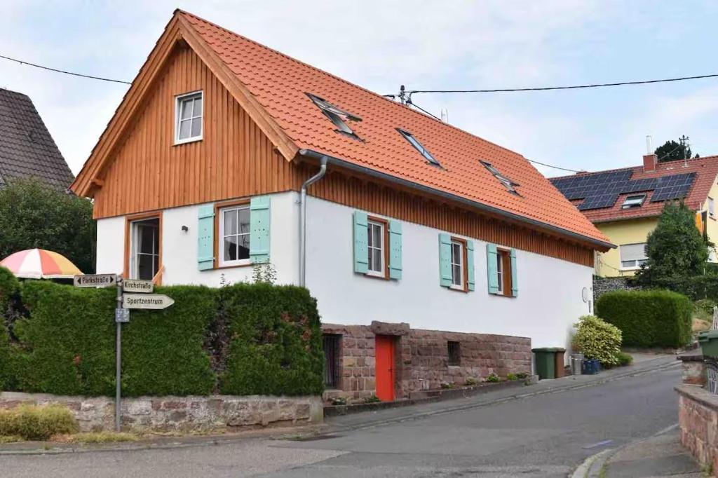 a white house with an orange roof on a street at Zita Ferienhäuser - Ferienhaus Feni in Neckargemünd