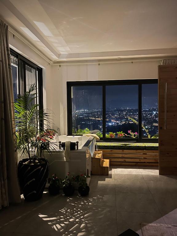 a bedroom with a large window with a city view at Residence Gratia by Eagle View in Kigali