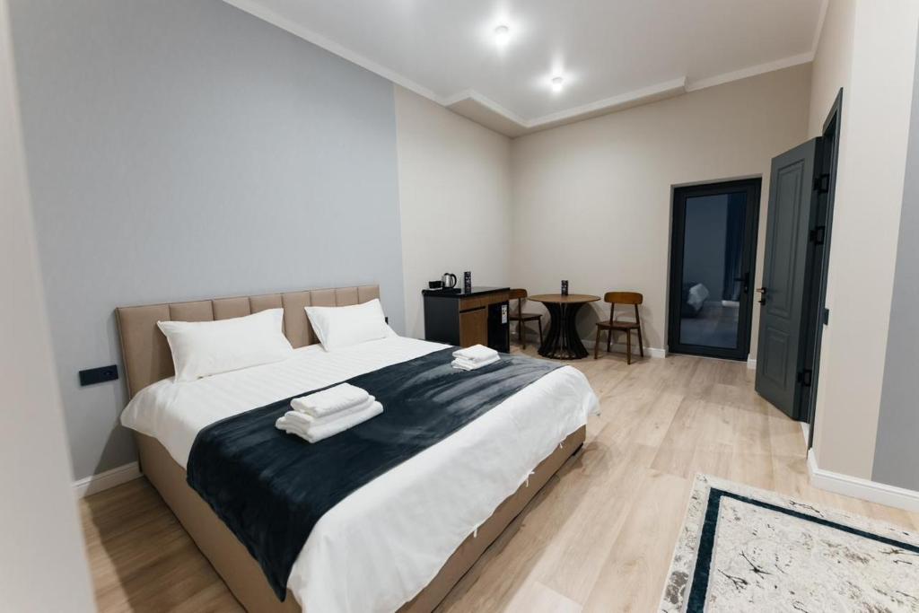 a bedroom with a large bed with towels on it at AURA hotel in Taraz