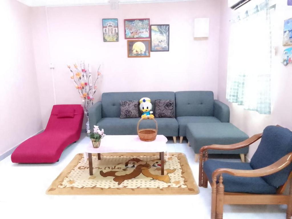 a living room with a blue couch and a table at Sunny day vacation home fully aircon in Kampong Bagan Lalang