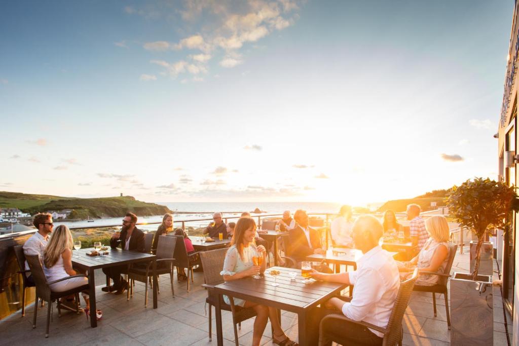 a group of people sitting at tables in a restaurant at The Beach in Bude