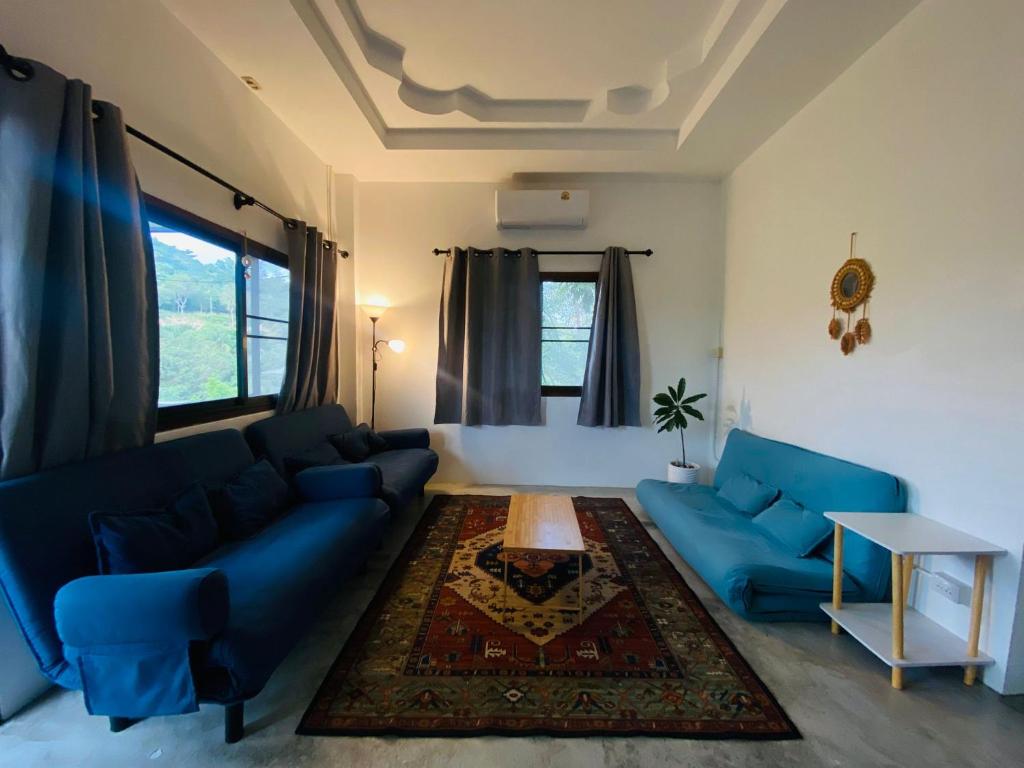 a living room with a blue couch and a table at Sabai Homes 3 in Mae Haad