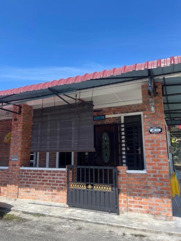 a brick building with a gate in front of it at Homestay Anjang in Tapah