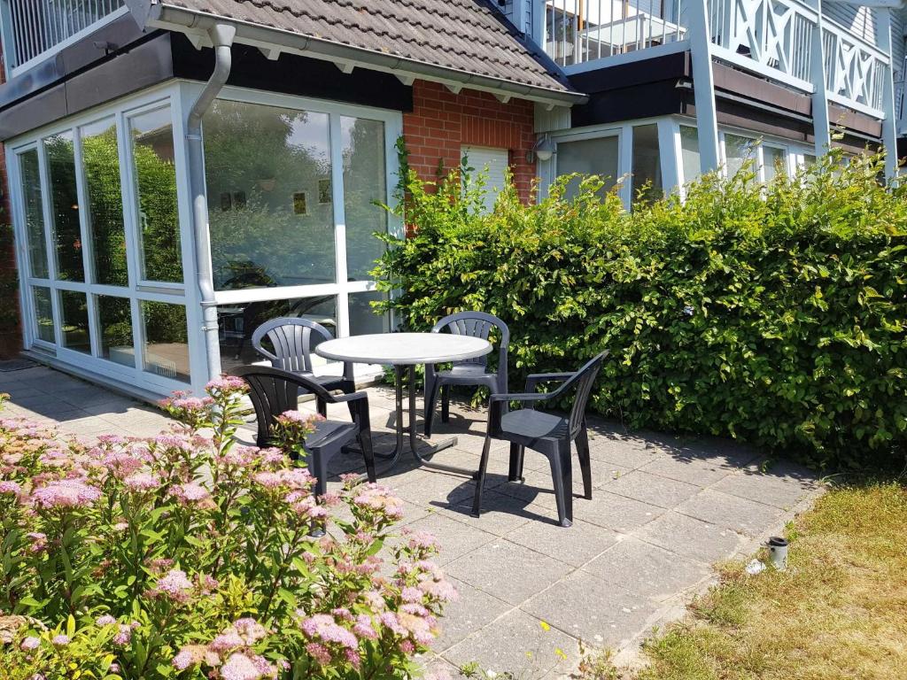 a patio with a table and chairs in front of a building at Fewo 1 im Fischerhaus mit Wintergarten und Terrasse in Seedorf