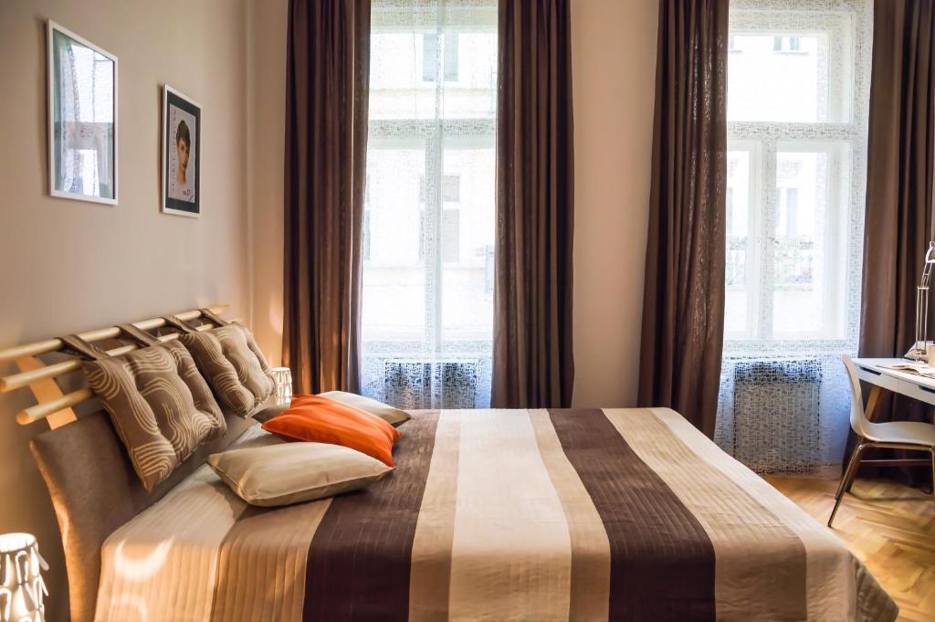 - une chambre avec un grand lit et des oreillers orange dans l'établissement Modern Apartment Zlatnicka 8, à Prague