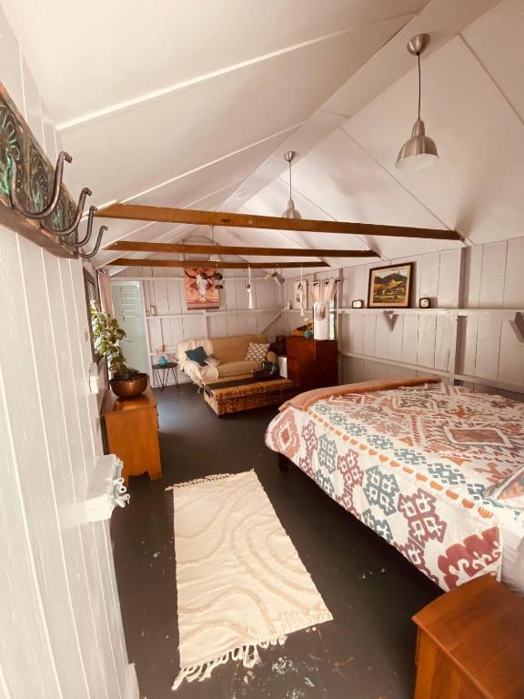 a bedroom with a bed and a living room at Wech Cottage in Warkworth