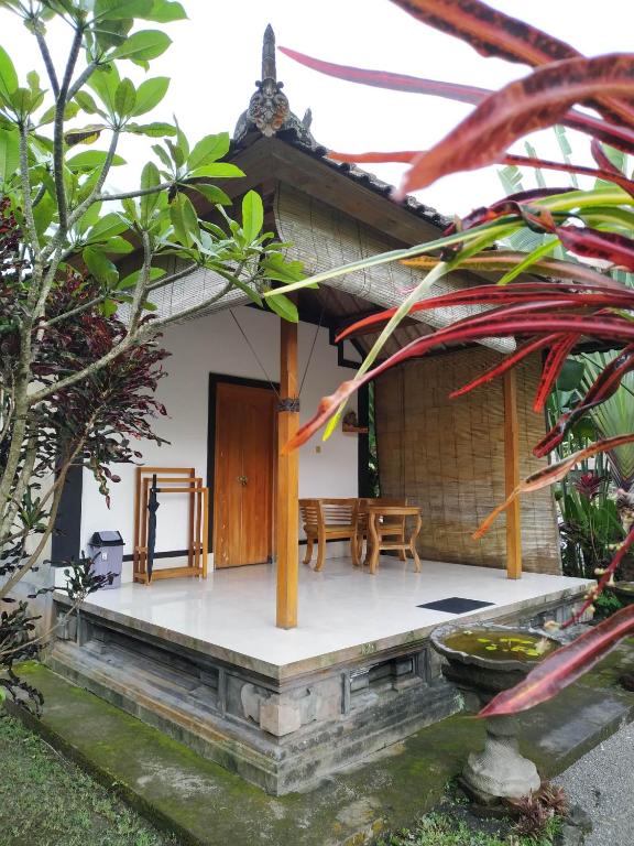 a small house with a porch and a table at The Bukit Artha in Sidemen