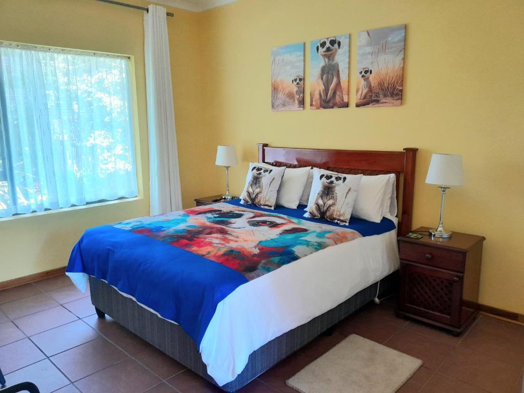 a bedroom with a bed with a blue comforter at Meerkat Manor on Main in Clarens