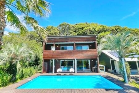 a house with a swimming pool in front of a house at プールサイドヴィラ館山 in Tateyama