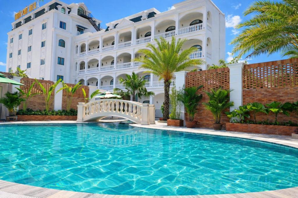 a swimming pool in front of a building at Thuận Phát Hotel in Soc Trang