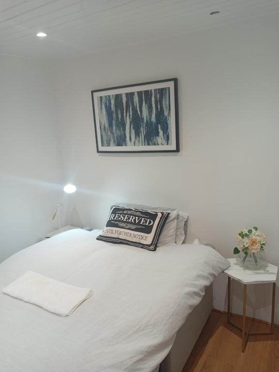 a white bed with a pillow on top of it at Lovely Timber Lodge Ensuite room in Corby Town centre NN17 in Rockingham