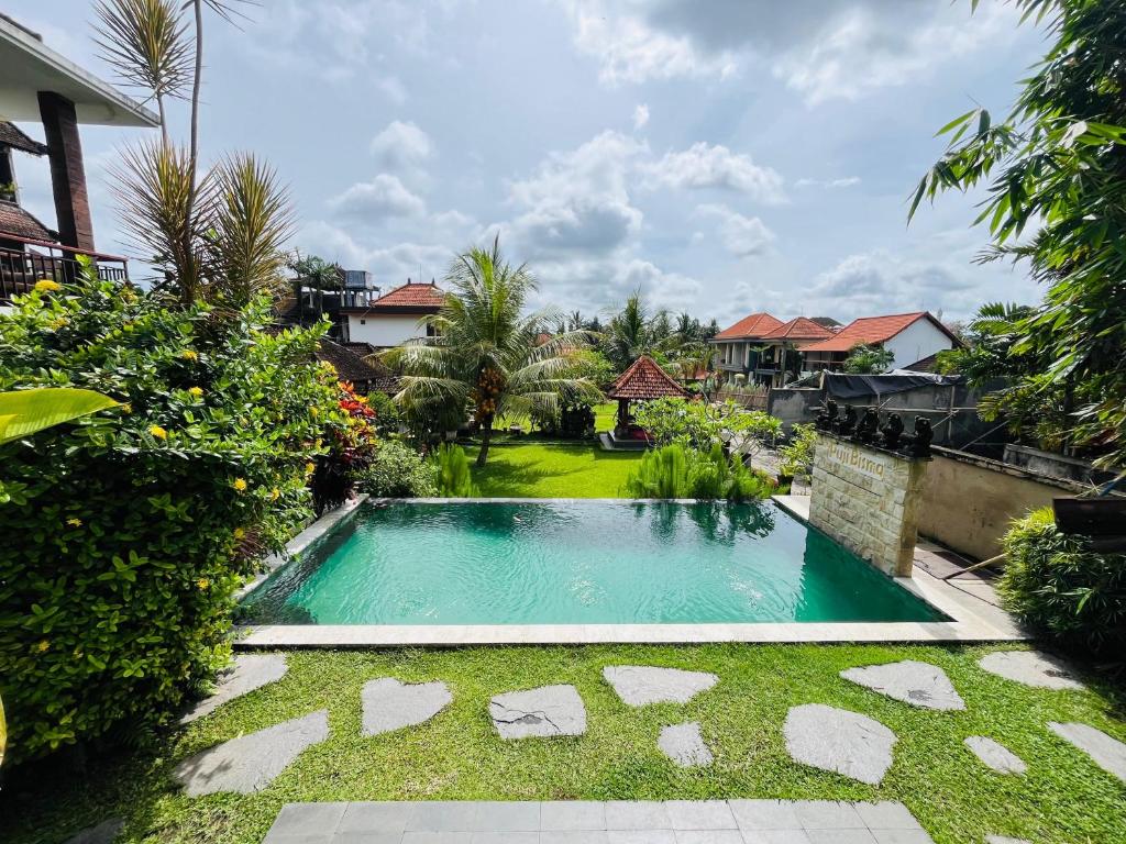a swimming pool in the yard of a house at Puji Bisma Ubud in Ubud