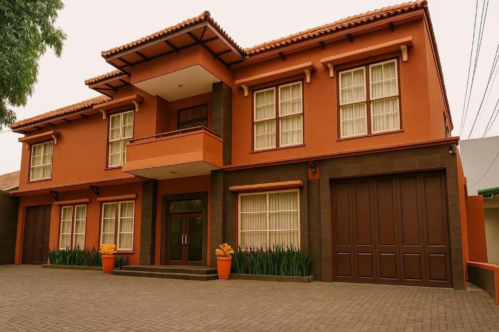 a orange house with a garage at tekMIRA Hotel in Bandung