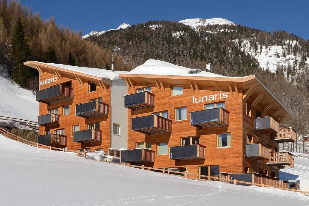 ゼルデンにあるLunaris Apartの雪の中にバルコニーが付いた大きな建物