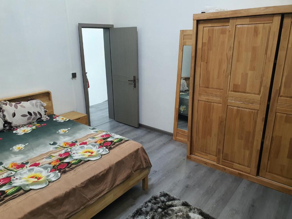 a bedroom with a bed and a wooden cabinet at Jannat Residence in Curepipe
