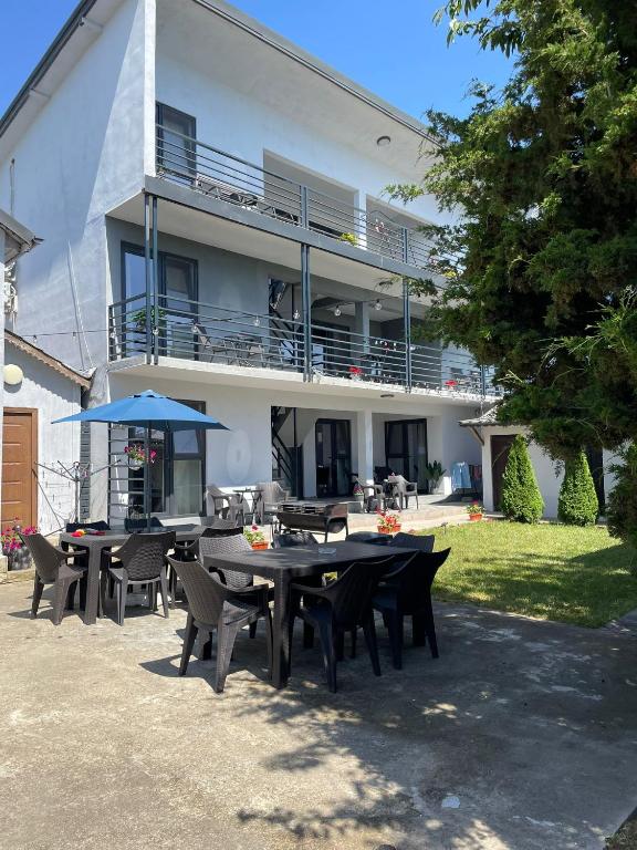 a group of tables and chairs in front of a house at Vila B&P in Costinesti