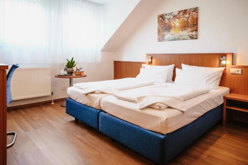 ein Schlafzimmer mit einem großen Bett in einem Zimmer in der Unterkunft Hotel & Restaurant Goldener Pflug in Ludwigsburg
