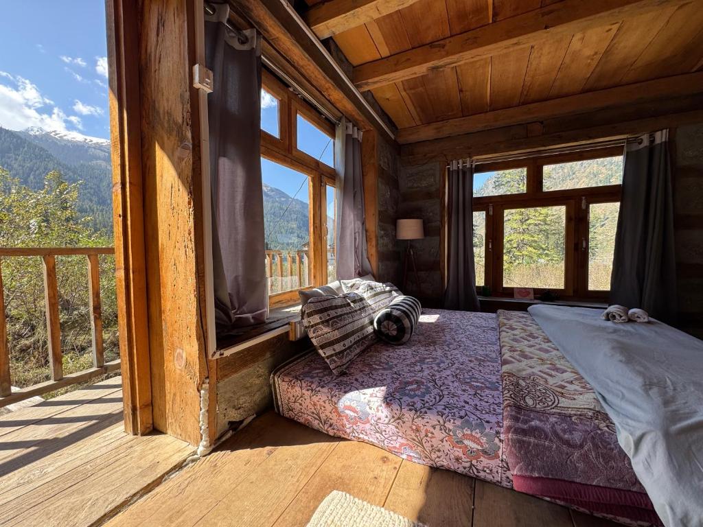 a bedroom with a bed in a room with windows at Enter The Wild in Kalgha