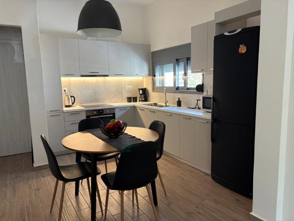 a kitchen with a table and chairs and a black refrigerator at Elena's House in Methana