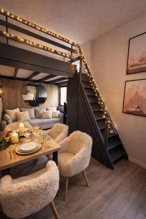 a living room with a staircase and a table and chairs at Ma Montagne Chic 4 in La Bresse