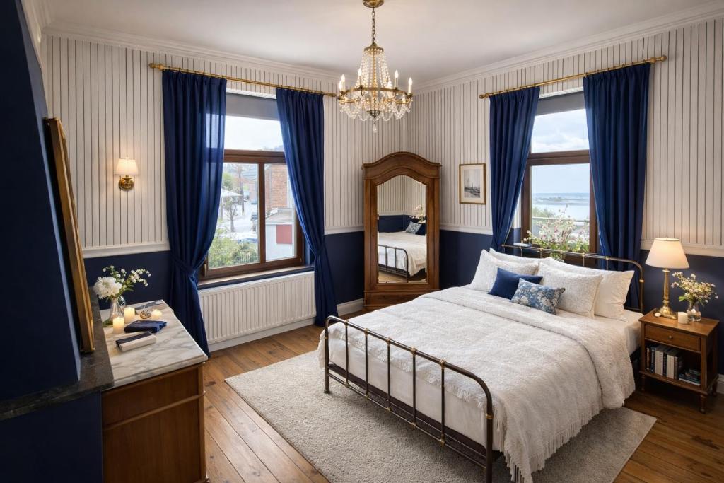 a bedroom with a bed with blue curtains and a mirror at Maison de Maître in Liège