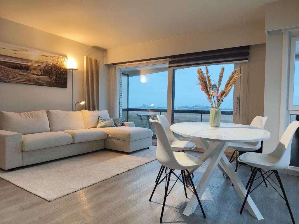 a living room with a white couch and a table at SeaStay - vernieuwde badkamer en interieur living in Knokke-Heist