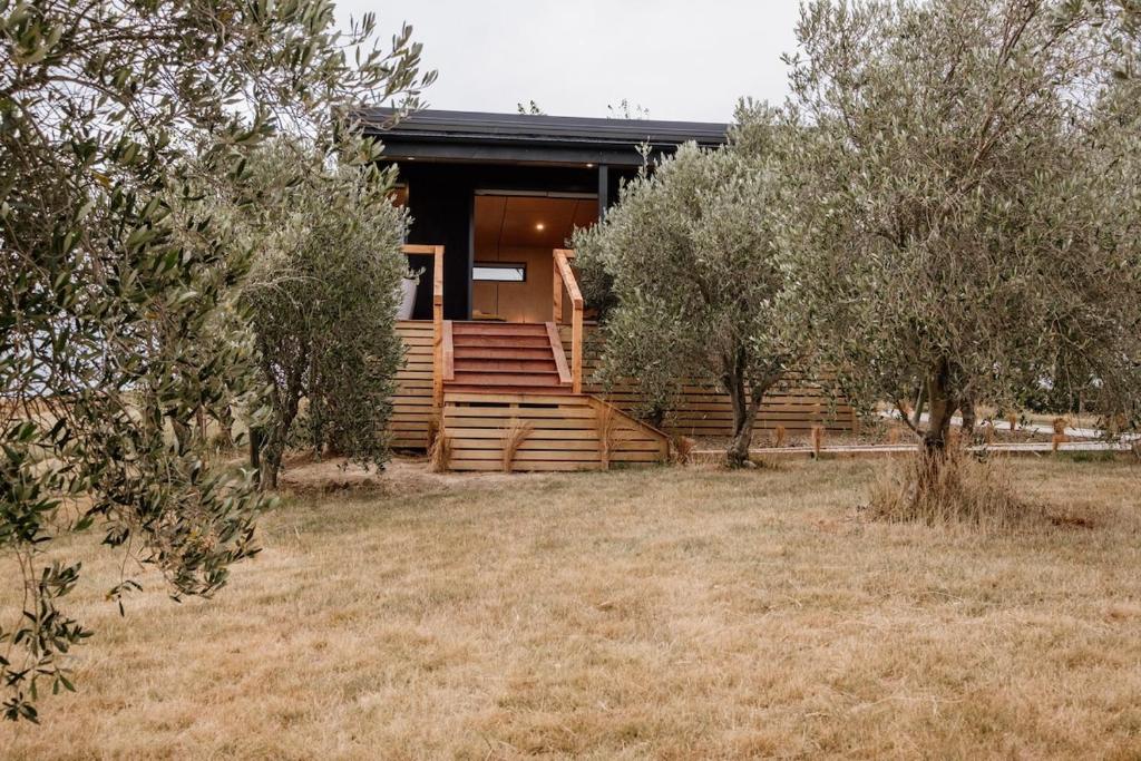 a wooden house with trees in front of it at Casa Olea in Waipara