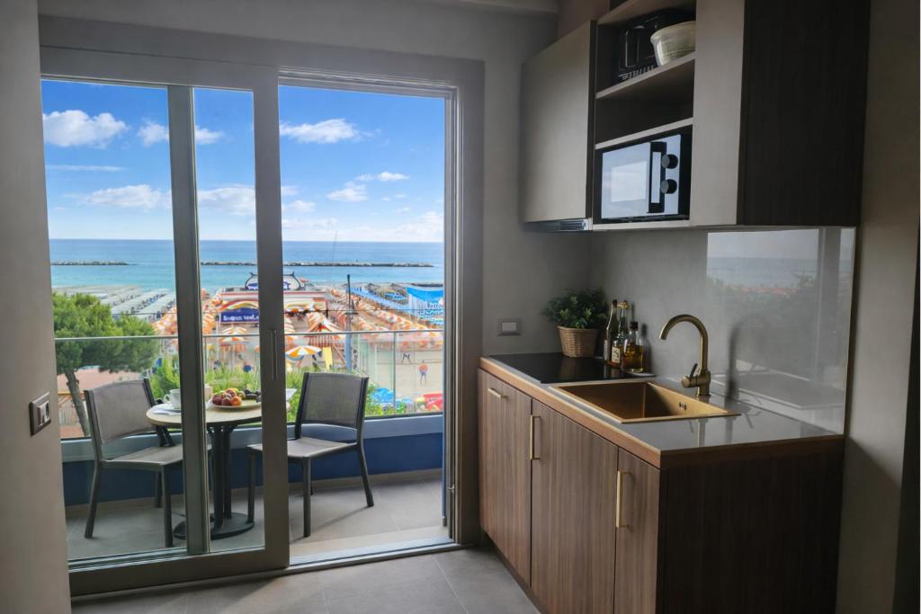 a kitchen with a view of the ocean from a balcony at Frontemare Appartamenti e Camere ELISABETTA in Cesenatico