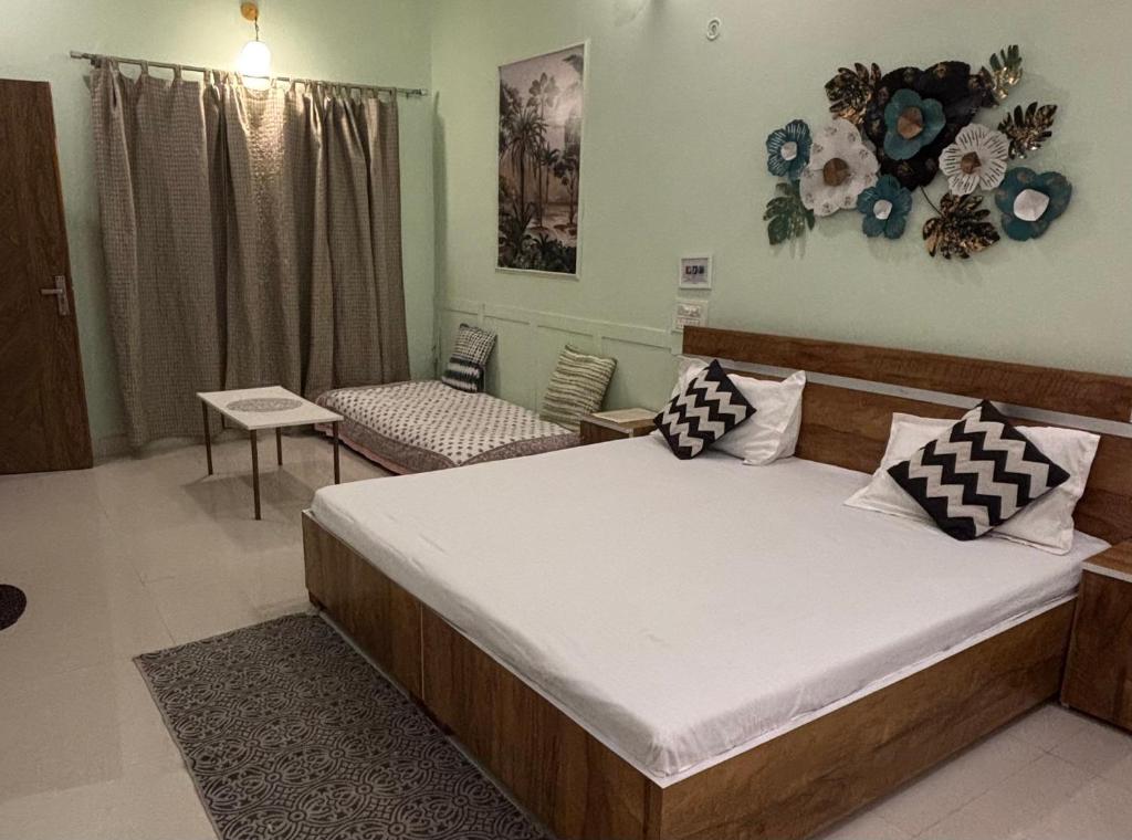 a bedroom with a large bed and a couch at Peepal in Aranyaa Cottage Homestay Vrindavan in Vrindāvan